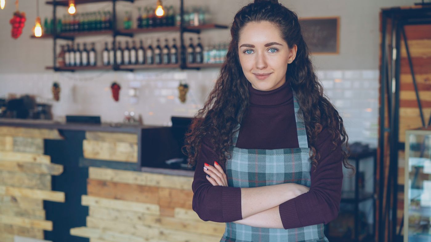 A small business owner in a warmly-lit shop