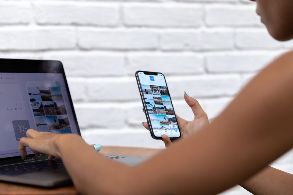 Person creating social content on phone and laptop